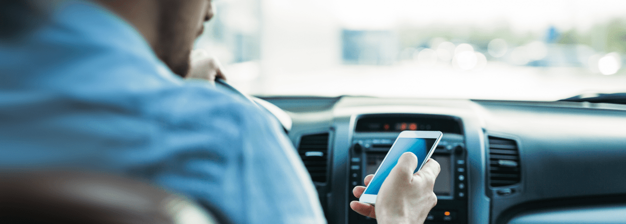 Man gebruikt mobiele telfoon tijdens het rijden